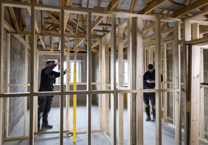 Wide shot of two male builders working on a property in Bloomington IL.