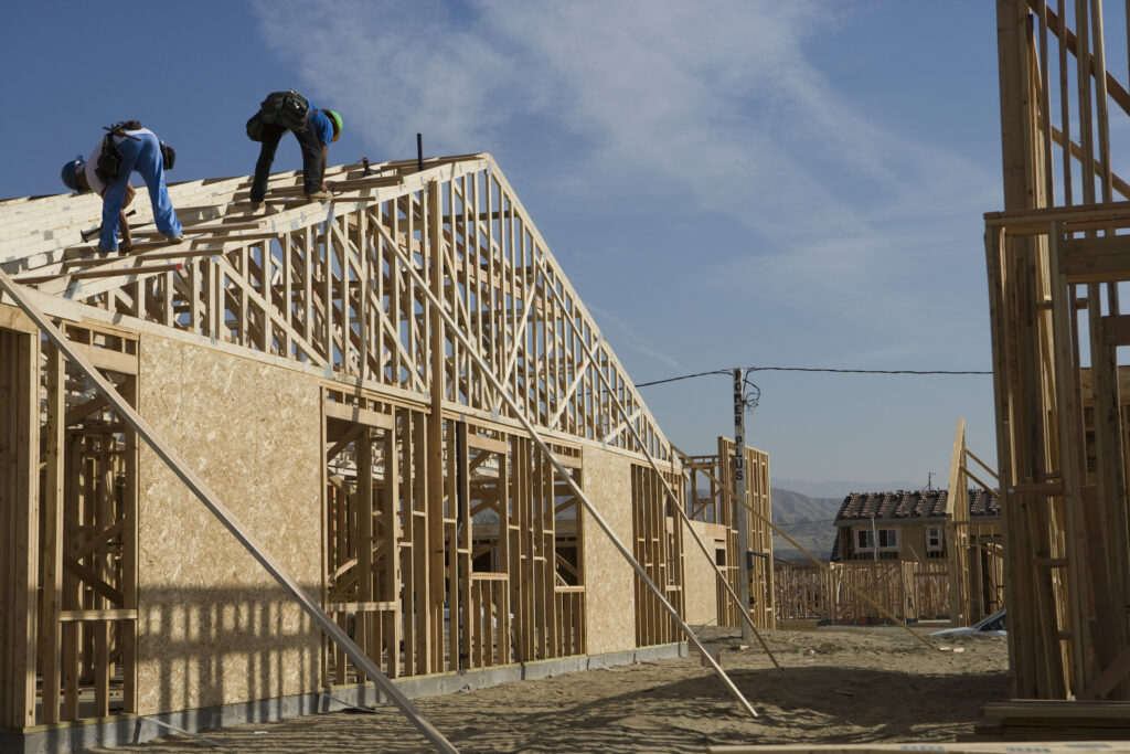 Team members from Central Illinois Construct, home builders in Peoria IL, work on a roof and new home